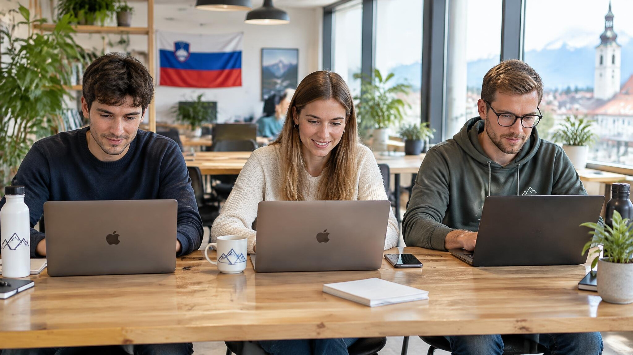 Colleagues working on laptops in a bright coworking space