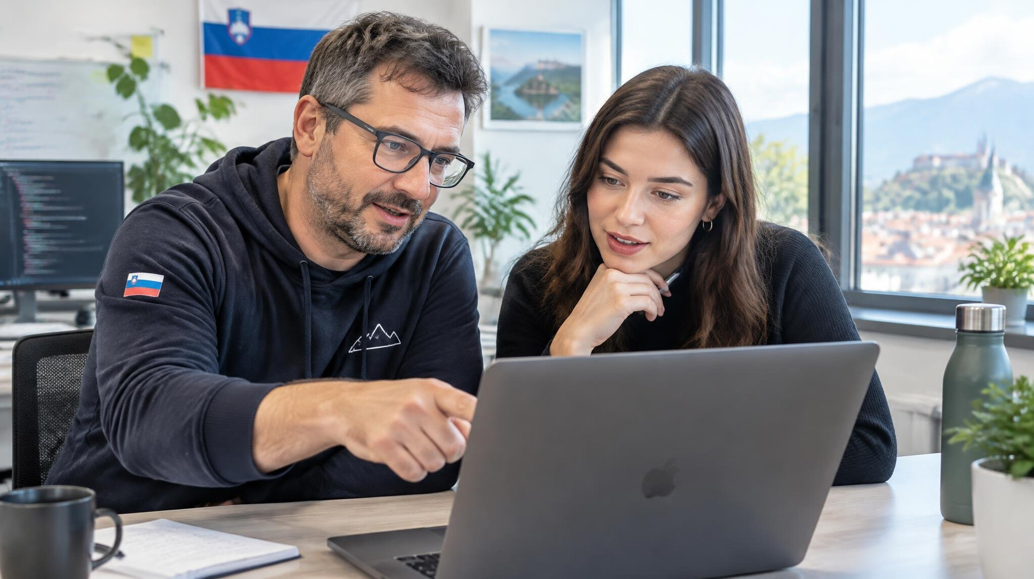 Mentor and mentee discussing at a table with a laptop